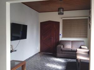a living room with a couch and a tv and a door at Cantinho do Nono in Olímpia
