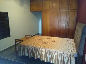 a bedroom with a bed and a wooden cabinet at Cantinho do Nono in Olímpia