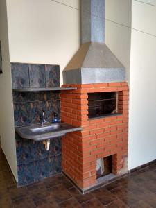 a kitchen with a brick oven with a sink at Cantinho do Nono in Olímpia