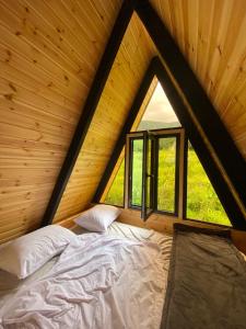 Bett in einem Zimmer mit einem großen Fenster in der Unterkunft Inn Martvili in Martvili