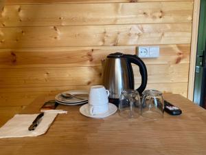 a tea kettle and glasses on a wooden table at Inn Martvili in Martvili