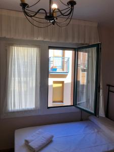 a bedroom with a bed and a window with a balcony at Habitación Doble in Estella