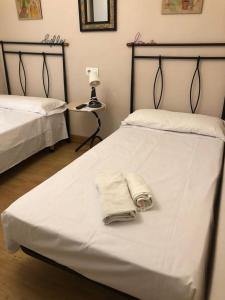 a bedroom with two beds with towels on them at Habitación Doble in Estella