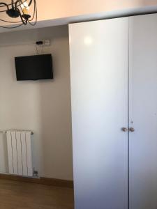 um armário branco num quarto com uma televisão em Habitación Doble em Estella