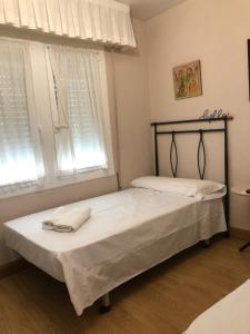 dwa łóżka w pokoju z dwoma oknami w obiekcie Habitación Doble w mieście Estella