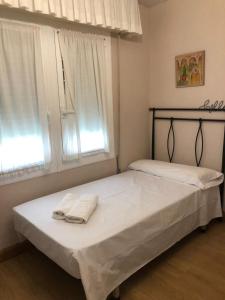 een slaapkamer met 2 bedden en handdoeken bij Habitación Doble in Estella