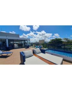 a swimming pool with two couches and a swimming pool at Flat Beira Mar Maracaípe- Porto de Galinhas in Porto De Galinhas