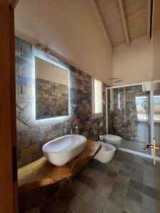 a bathroom with two sinks and a tub and a toilet at Incanto Glamping village in Savio di Ravenna