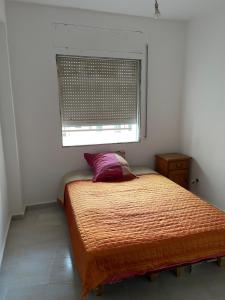 a small bedroom with a bed with a window at Super Appart T3 Tanger Mesnana in Tangier