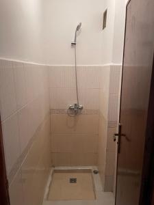 a shower in a tiled bathroom with the door open at Super Appart T3 Tanger Mesnana in Tangier