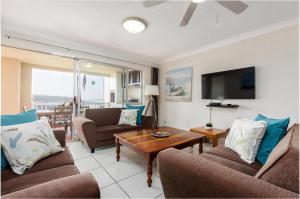 a living room with two couches and a table at Laguna La Crete 41 in Uvongo Beach
