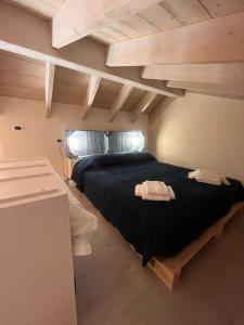 a bedroom with a black bed with two towels on it at Incanto Glamping village in Savio di Ravenna