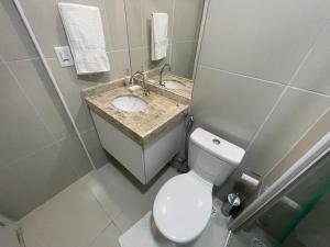 a bathroom with a toilet and a sink at Ap alto padrão a 50m do sobral shopping in Sobral