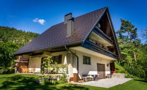 a house with a gambrel roof with a patio at Tourist house Capricorn in Bled