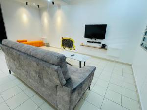 un salon avec un canapé et une télévision dans l'établissement EE Summer Guest House 3.0, à Seremban