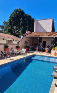 a swimming pool in front of a house at Suíte Theo in Blumenau