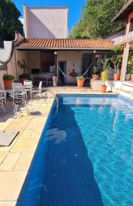 a swimming pool in front of a house at Suíte Theo in Blumenau