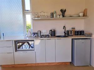 ノッティンガム・ロードにあるOur Place-at-Notties Self-contained 2-Bed unit in Nottiesの白いキャビネットとカウンタートップを備えたキッチン +4枚の写真