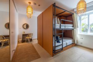 a room with bunk beds and a dining room at Selina Serenity Rawai Phuket in Rawai Beach
