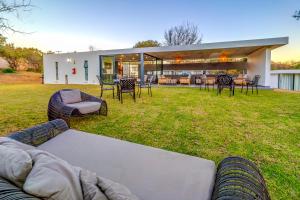 a house with a couch and chairs in a yard at KRAVIT Premier Suites in Midrand