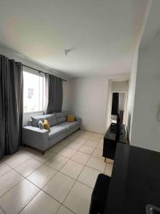 a living room with a couch and a window at Apartamento na Zonal Sul 2 Vagas Carro in Uberlândia