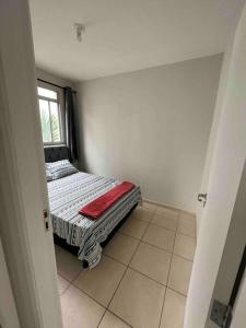 a small bed in a room with a window at Apartamento na Zonal Sul 2 Vagas Carro in Uberlândia