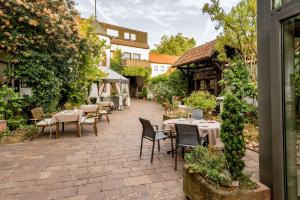 a patio with tables and chairs in a garden at Hotel & Weinhaus Anker in Marktheidenfeld