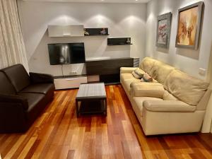 a living room with a couch and a tv at Espectacular piso cerca de la playa in Barcelona
