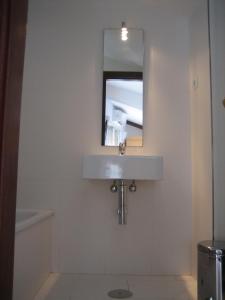 a white sink in a bathroom with a mirror above it at Residencia Universitaria San José in Málaga