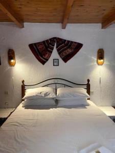 una camera da letto con un grande letto bianco con due luci di Villa Kamari- Stunning Views a Kritsa