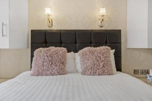 a bed with two pink pillows on top of it at Luxury Oceana Apartment, Central City Centre, Newly Refurbished in Plymouth
