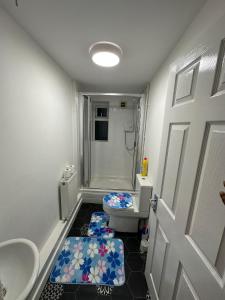 a bathroom with a toilet and a shower and a door at Liberty Inn Room with sharing toilet and kitchen in Liverpool