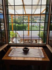 Habitación con ventana grande y jarrón sobre una mesa. en Villa Kamari- Stunning Views, en Kritsá