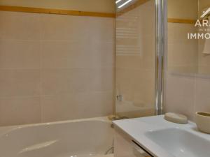een witte badkamer met een bad en een wastafel bij Appartement Le Grand-Bornand, 4 pièces, 6 personnes - FR-1-391-134 in Le Grand-Bornand