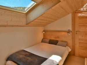 een slaapkamer met een bed in een kamer met een raam bij Appartement Le Grand-Bornand, 4 pièces, 6 personnes - FR-1-391-134 in Le Grand-Bornand