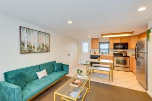 a living room with a blue couch and a kitchen at Long Island Studio Vacation Rental 4 Mi to Beach 