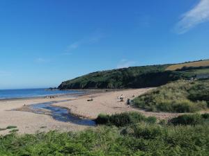 a group of people on a beach near the ocean at 'Le Chalet II' free unlimited wifi 2 bed chalet House in Pembrokeshire