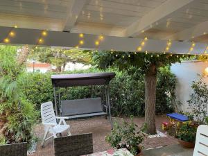 a patio with a bench under a canopy with lights at Villa G55C RosaMarina in Rosa Marina