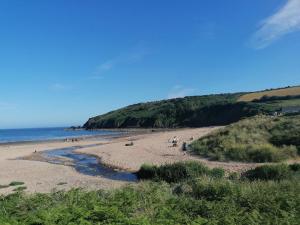 a group of people on a beach near the ocean at Le Chalet - 2 Bedroom Chalet House sleeps 3 in Pembrokeshire