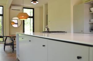 eine Küche mit einer weißen Theke und einem Esszimmer in der Unterkunft NorthShore Modern Cabin 626 in Northport