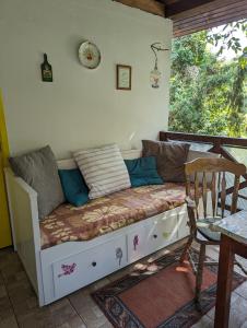 - un lit sur une terrasse couverte avec une table et une chaise dans l'établissement Lóci Palócház, à Nagylóc