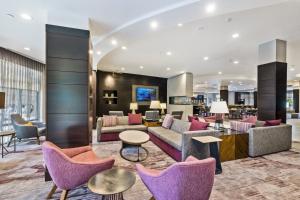 a hotel lobby with purple chairs and tables at Courtyard by Marriott Boston Waltham in Waltham