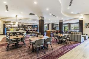 a restaurant with tables and chairs and a bar at Courtyard by Marriott Boston Waltham in Waltham