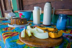 a table with a cutting board with food on it at Pousada Luz da Vila Itaúnas in Itaúnas