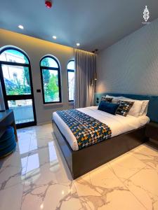 a bedroom with a large bed and some windows at Saladin Boutique Hotel in Jerusalem