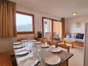 a dining room with a table with plates and chairs at Appartement spacieux 4 pièces avec 3 chambres, balcon, proche télésiège à SuperDévoluy - FR-1-525-201 in Le Dévoluy