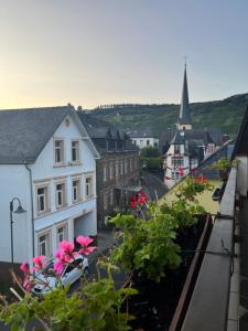 - une vue sur une ville aux fleurs roses et une église dans l'établissement Landhotel-Restaurant Wolfshof, à Traben-Trarbach