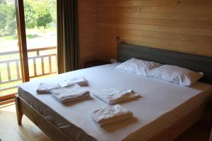 ein Bett mit Handtüchern und einem großen Fenster in der Unterkunft Villa Bilge in Cıralı