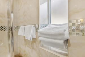 y baño con ducha y toallas blancas. en Luxury Mayflower Apartment, Central City Centre, Newly Refurbished, en Plymouth