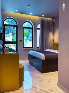 a bedroom with a bed and two windows at Saladin Boutique Hotel in Jerusalem